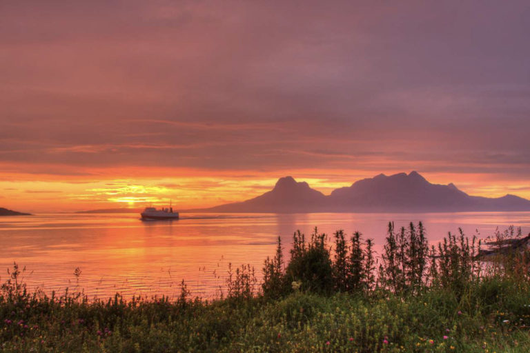 Mach den großartigen Aufbruch aus Bodø; nimm die Fähre über nach Moskenes und sieh dir die Sonne mitten im Fjord an © Tommy Andreassen