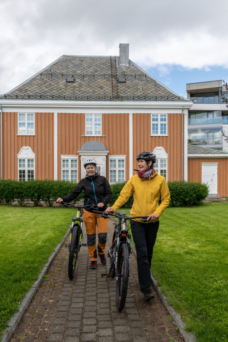 By bike in Harstad. In the background, the Store Spitsbergen Kulkompani house, built in 1919 in neo-barock style © Dag Roland / Visit Harstad