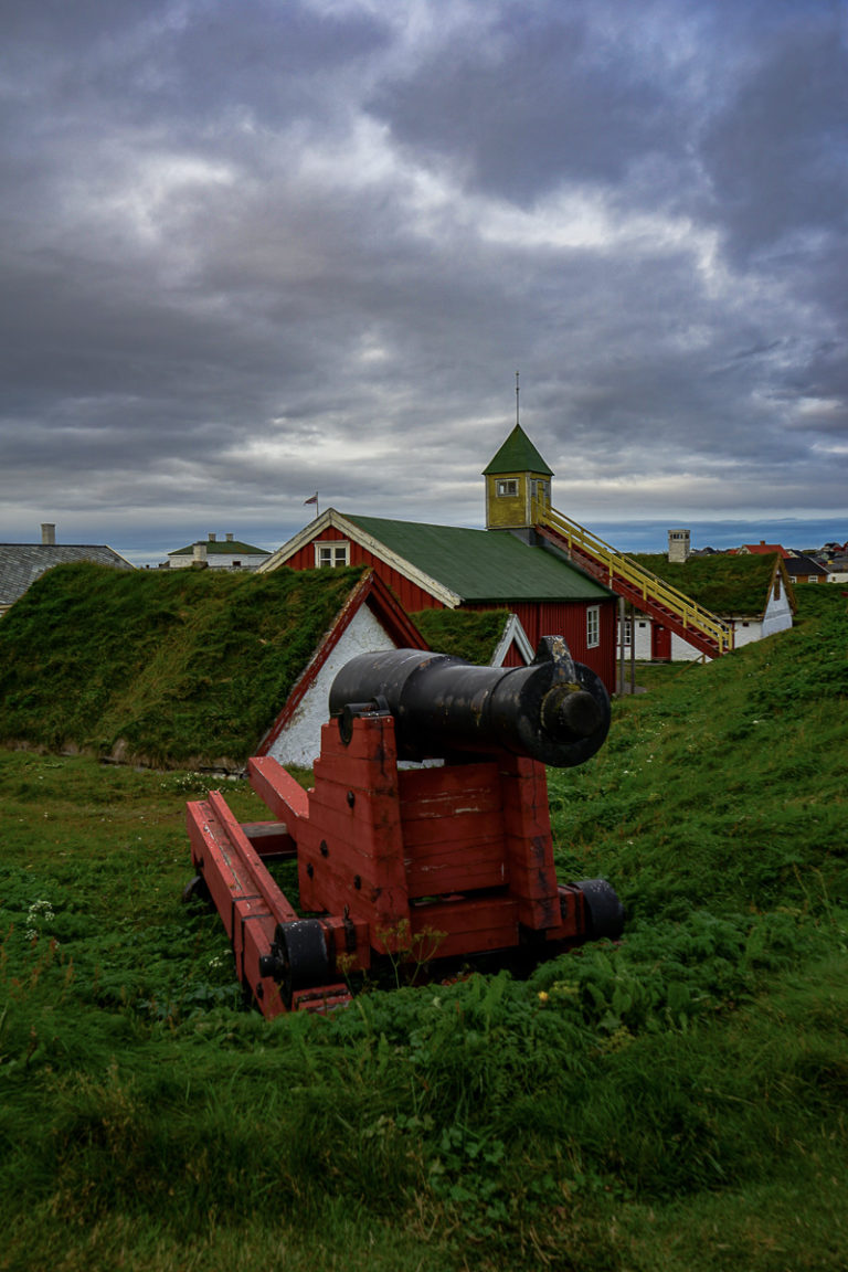 En kanon på vollen, og så de gamle husene inne i borggården på Vardøhus, verdens nordligste festning © Katelin Pell 