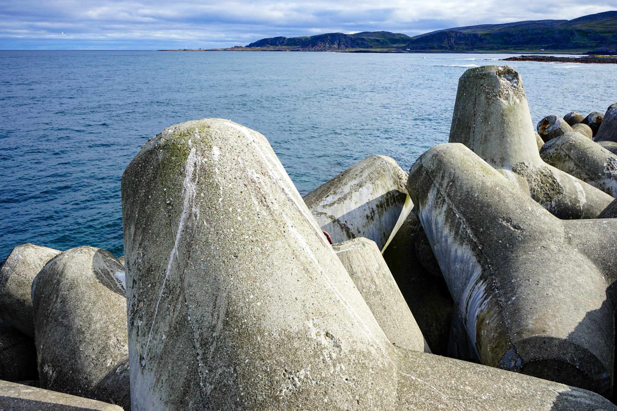 View past the tetrapods towards the Kjølnes lighthouse afar. In the north, there is nothing © Katelin Pell
