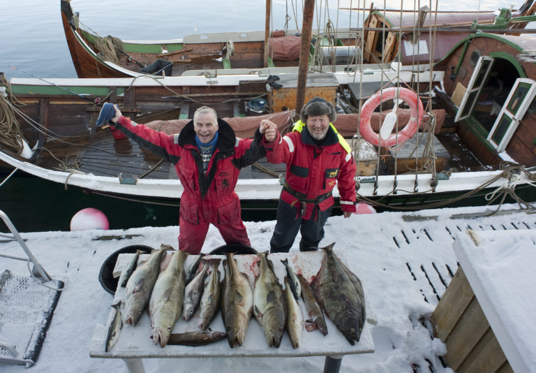 Happy fishermen at the Lofoten fishery with their traditional Nordlandsbåt. Foto: Ernst Furuhatt / nordnorge.prod.dekodes.no